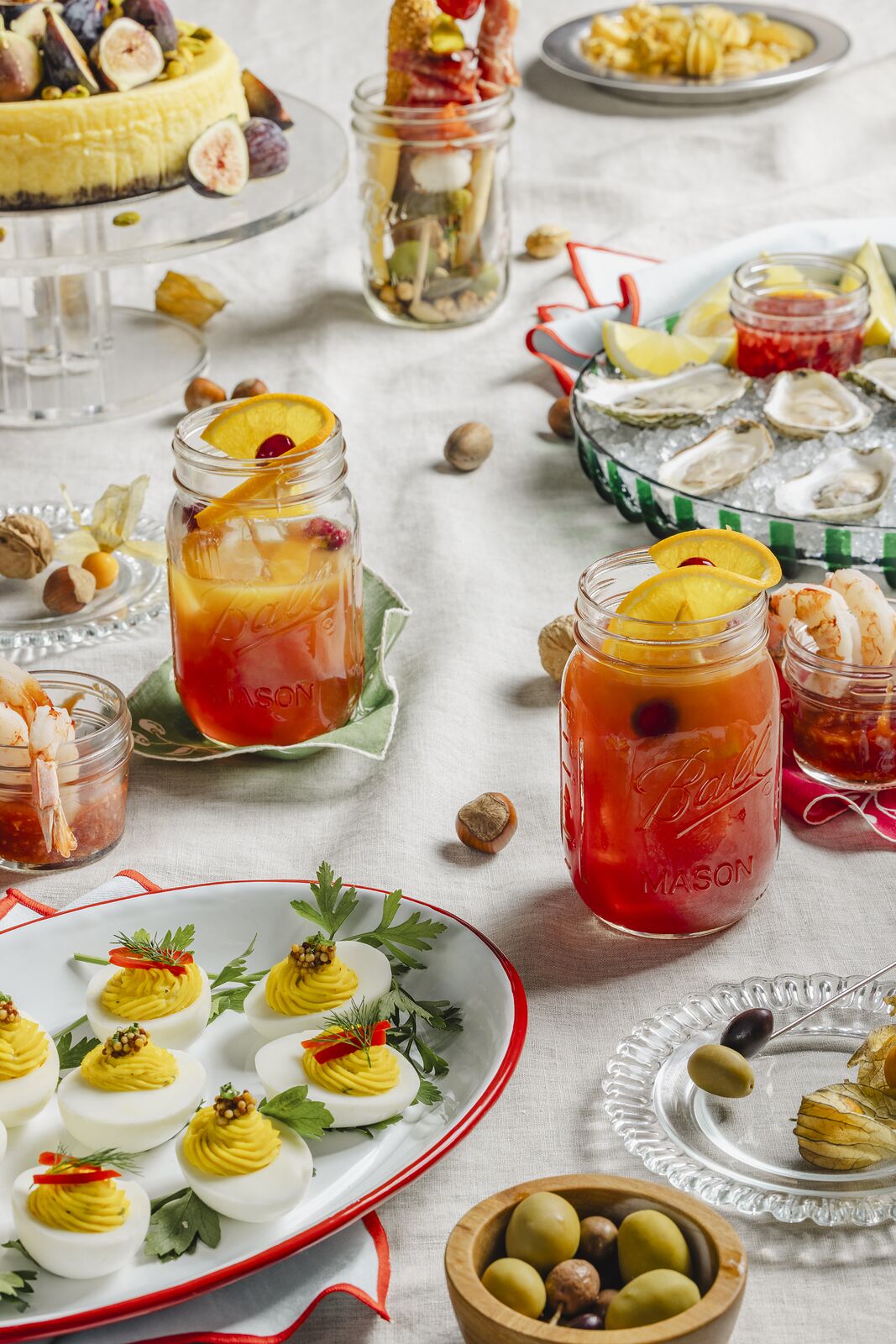 Party table of jar drinks and small plates with deviled eggs and sliced peaches